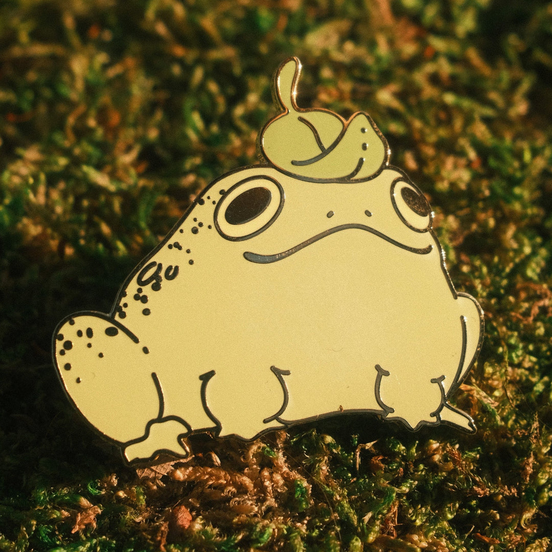 frog pin with leaf hat on a mossy background