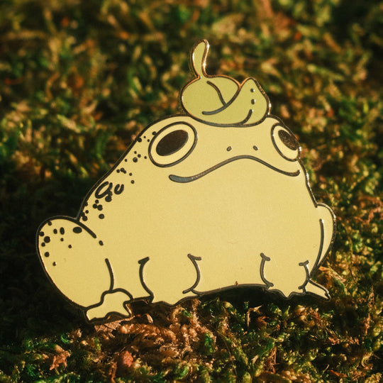 frog pin with leaf hat on a mossy background