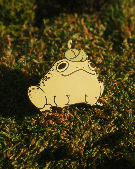 frog pin with leaf hat on a mossy background