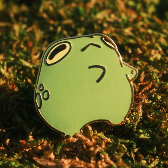 dancing frog pin on a mossy background
