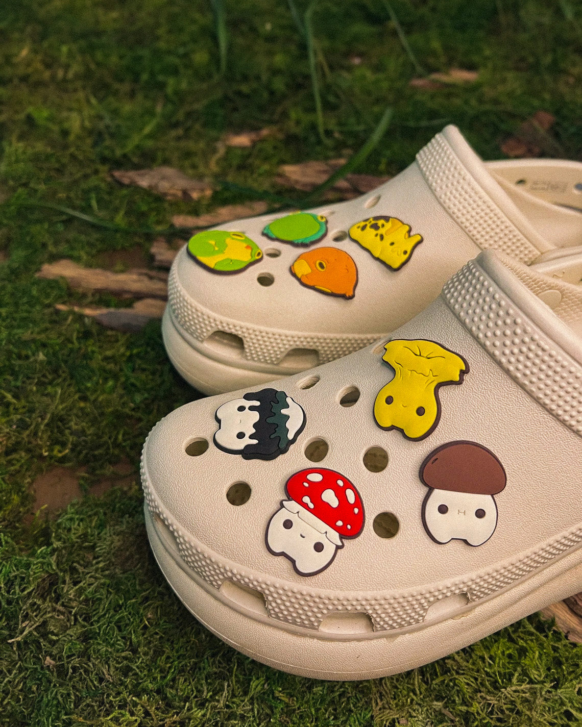 white crocs with charms of mushroom characters and frog characters on them