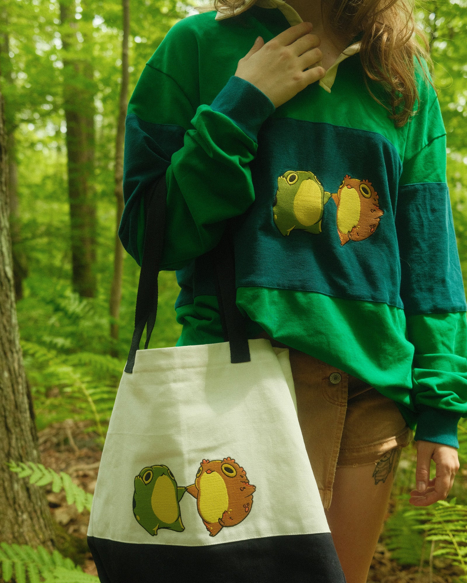 rugby shirt and tote bag with embroidered frog and toad dancing on them