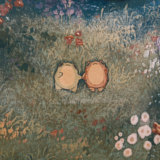 closeup of blanket of two frogs holding hands in a flowery field