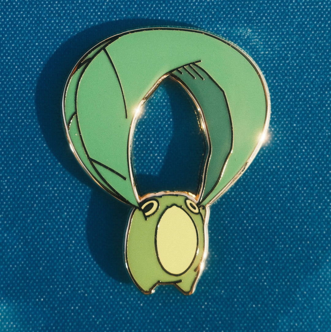 closeup of pin of frog gliding on a leaf