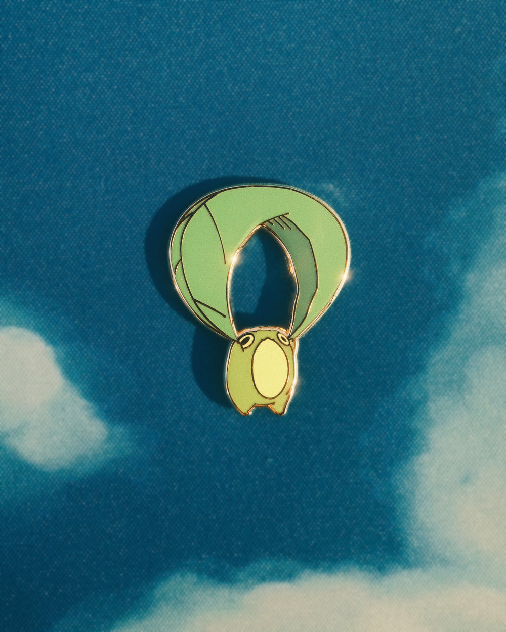 pin of a frog gliding on a leaf