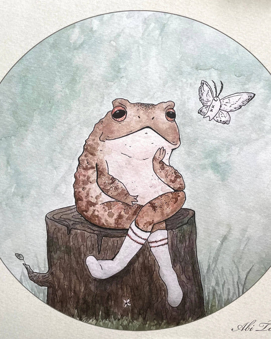 watercolor print with frog sitting on log next to a moth closeup