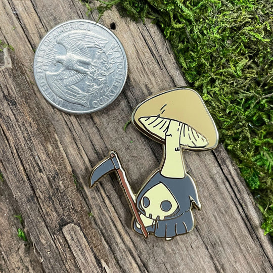 pin of death cap mushling next to quarter for reference