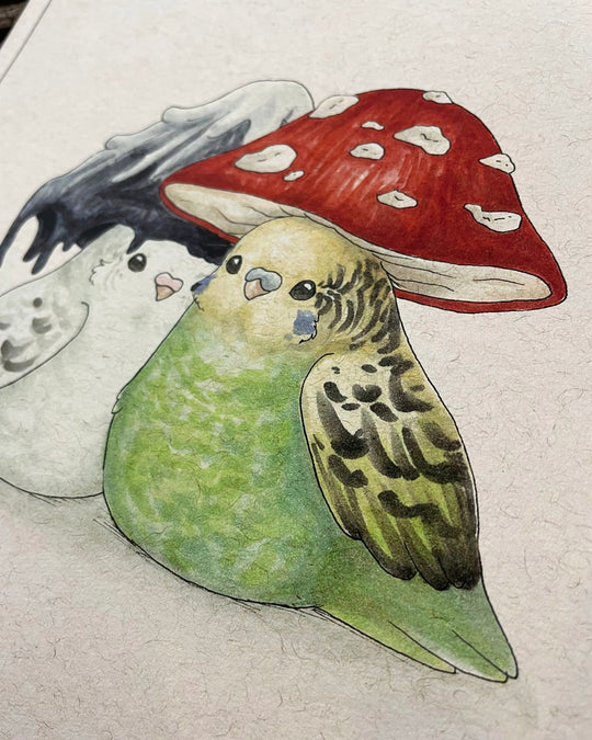 A print of two lovebirds with mushroom-shaped hats on their heads closeup