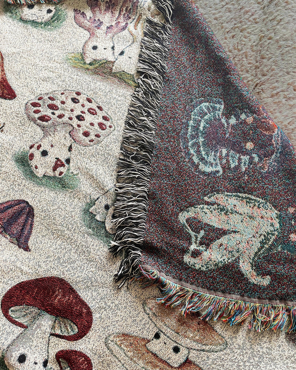 A queen-sized blanket with a woven design featuring various colorful mushroom characters closeup showing negative inverse side