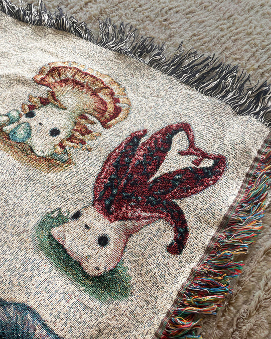 A queen-sized blanket with a woven design featuring various colorful mushroom characters closeup