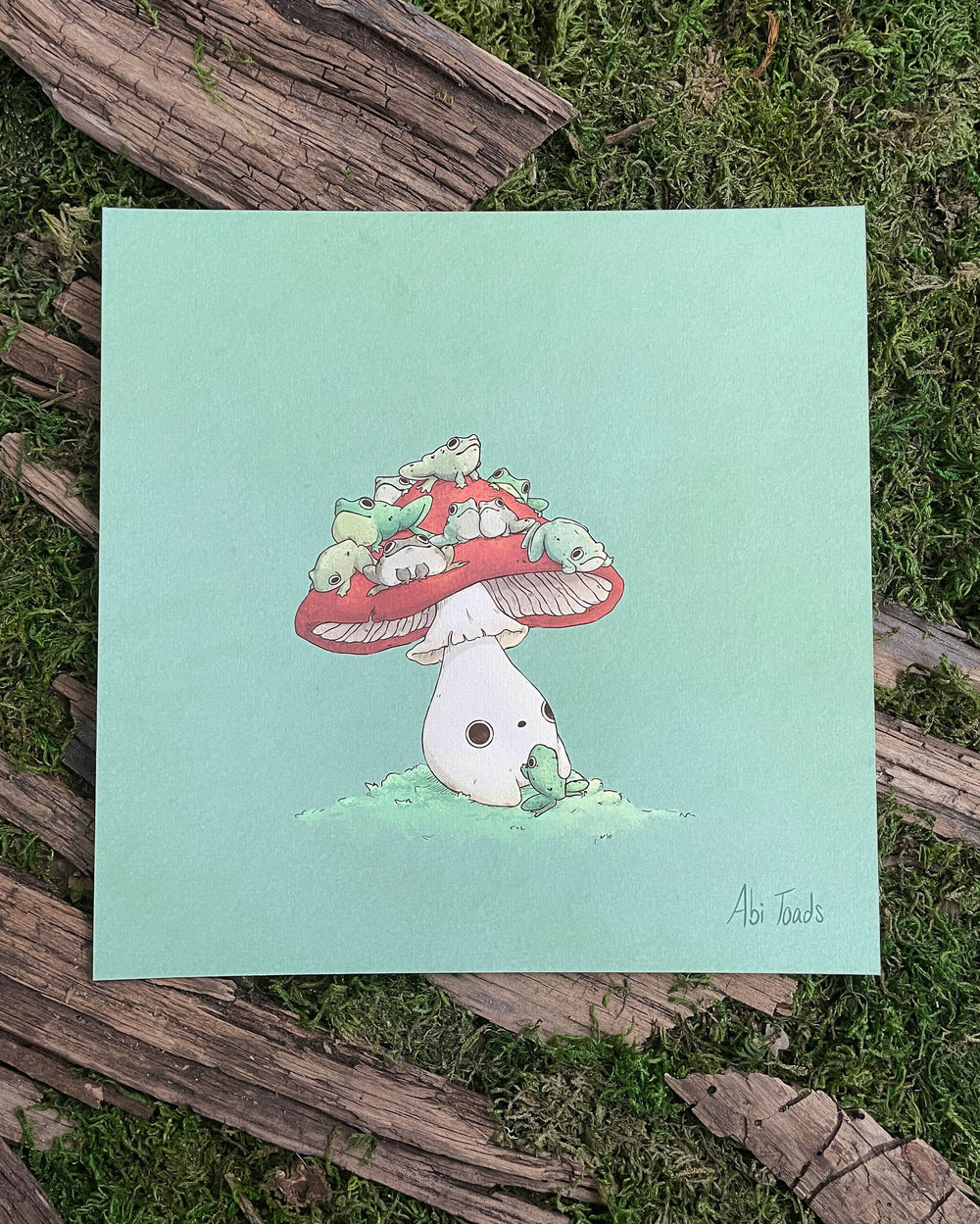 print of red capped mushling with many frogs sitting on top of his head