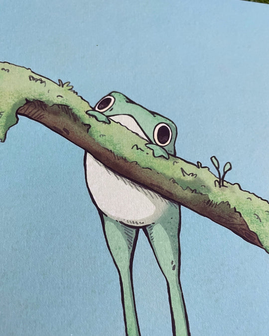 print of a frog handing on a mossy branch closeup