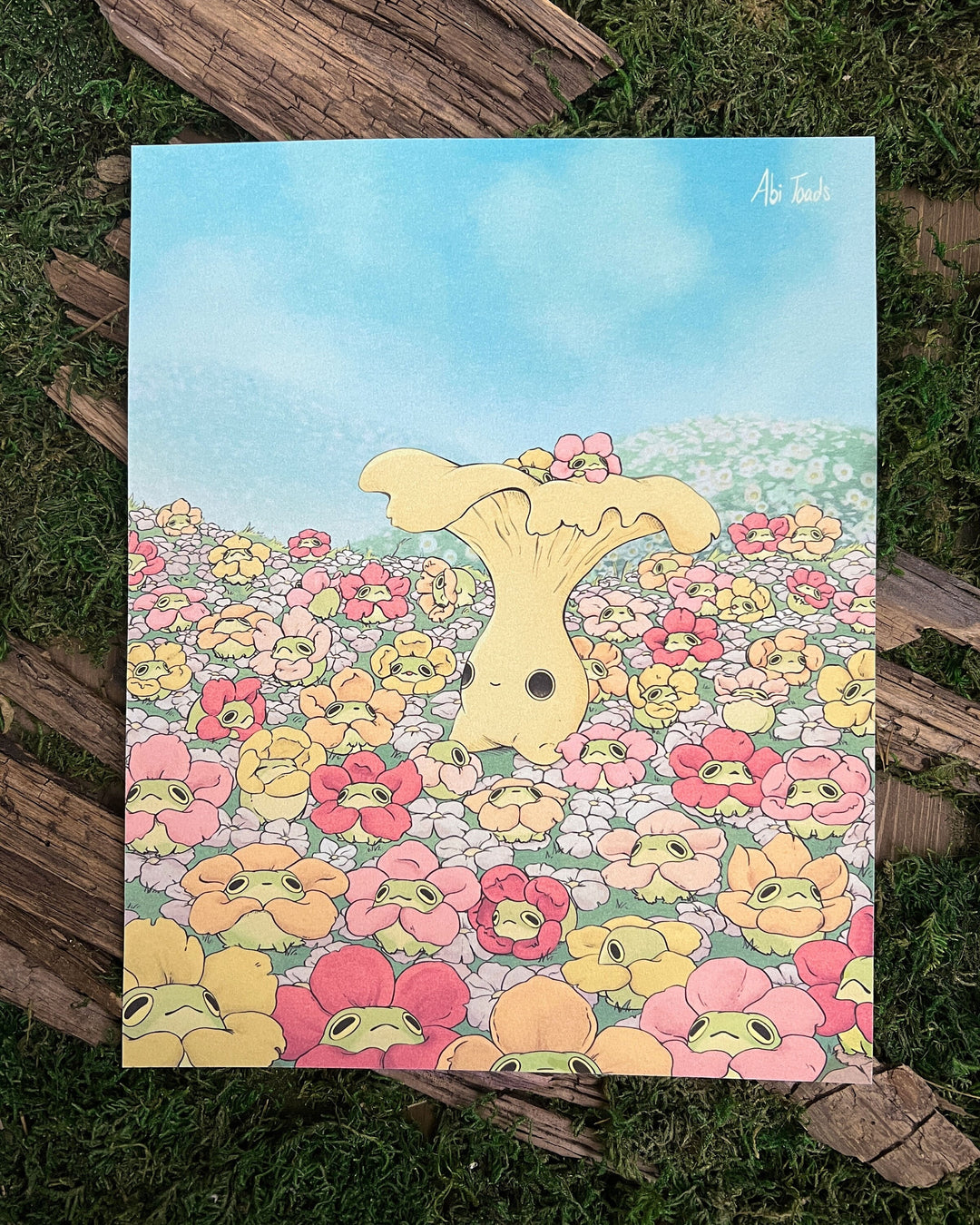 print of chanterelle mushling character surrounded by frogs in flower necklaces