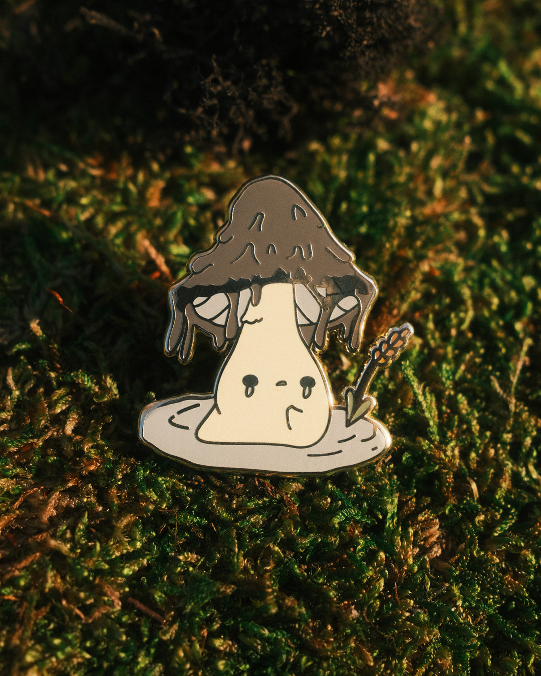 inky cap mushling pin on a mossy backfground