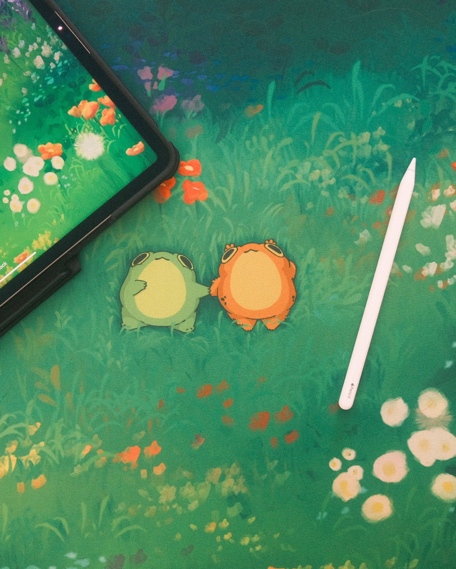 desk mat of two frogs holding hands in a flowery field