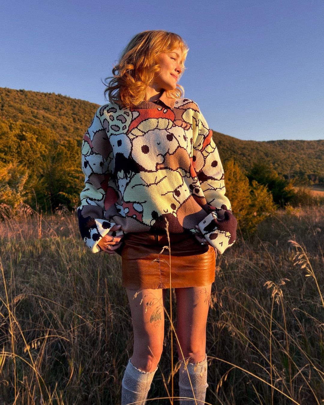 abi toads wearing a mushroom sweater in a field