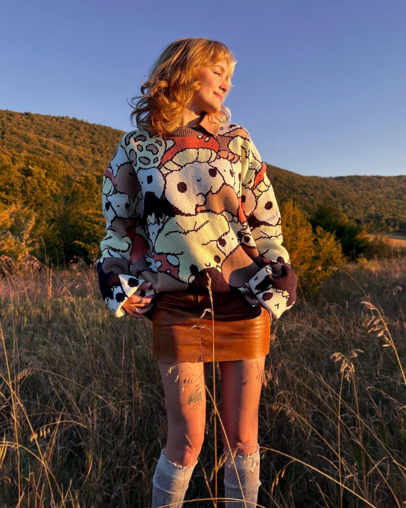 abi toads wearing a mushroom sweater in a field