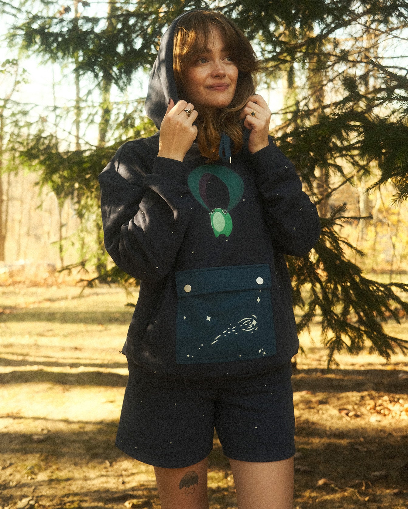 abi toads in a navy hoodie and shorts set of a frog gliding through the starry night on a leaf