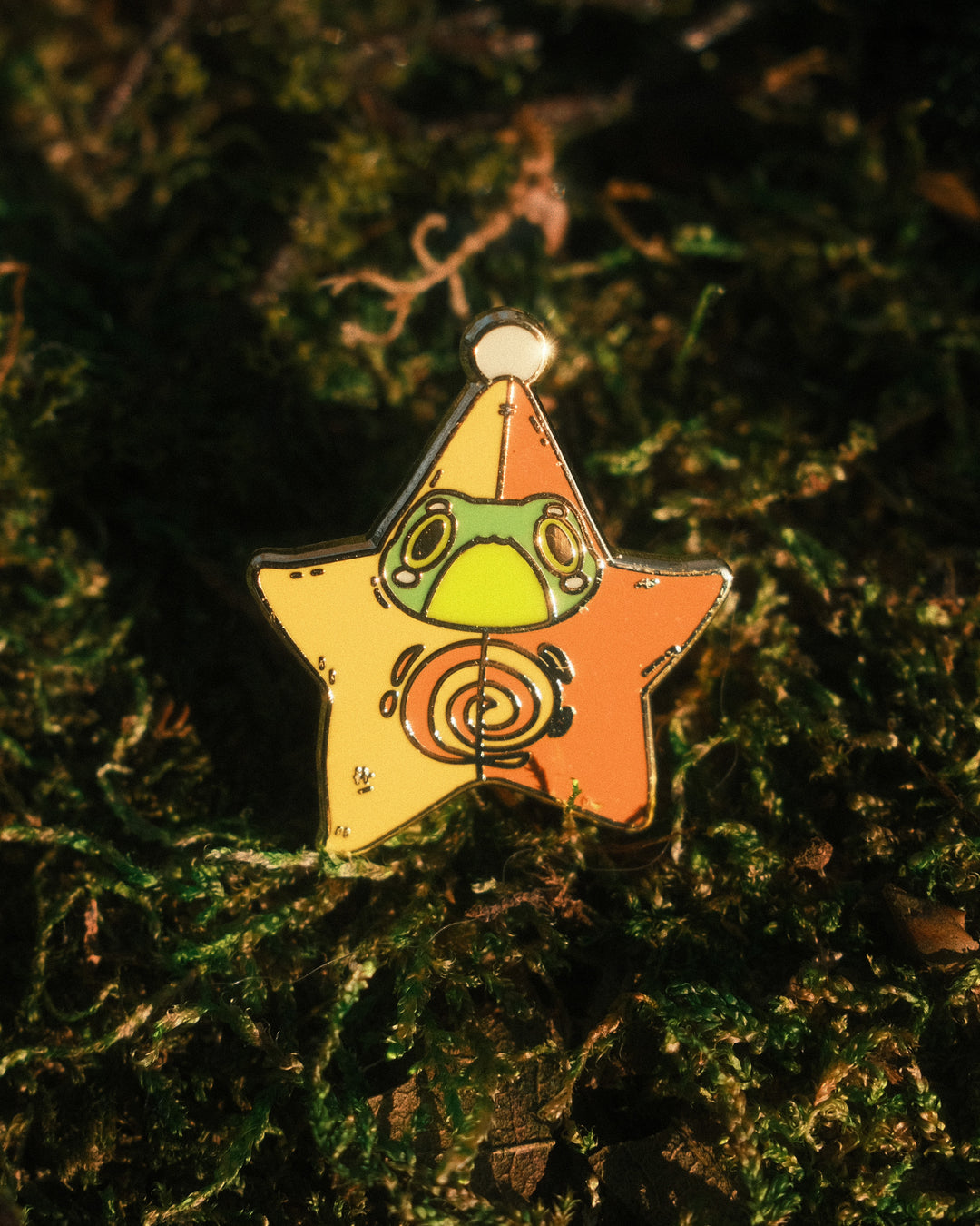 pin of frog in a star outfit on a mossy background