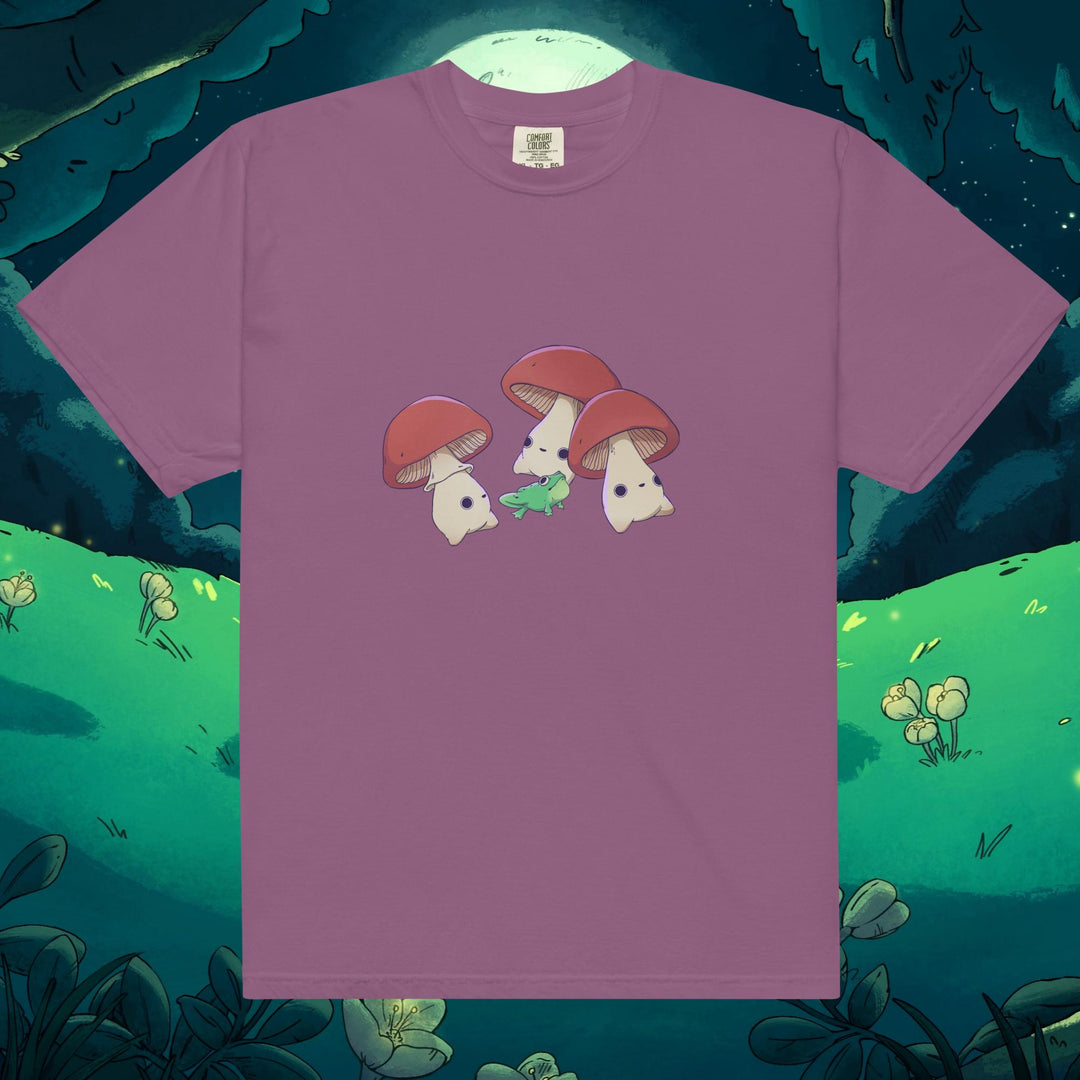 Product mockup of three mushrooms dancing around a frog on a tee shirt