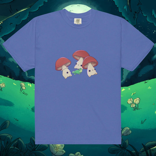 Product mockup of three mushrooms dancing around a frog on a tee shirt