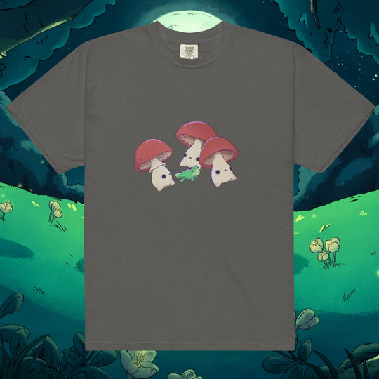 Product mockup of three mushrooms dancing around a frog on a tee shirt
