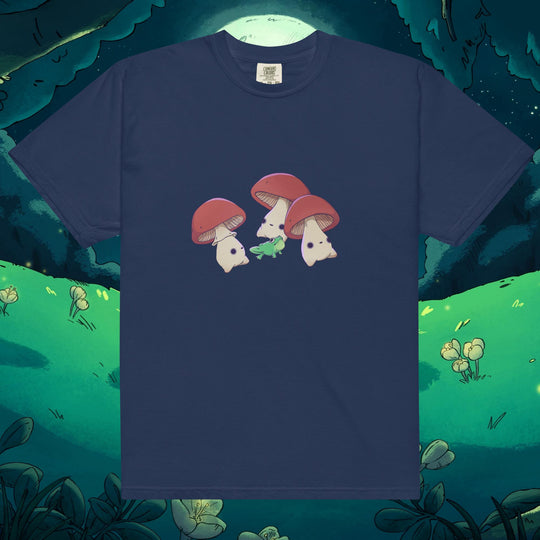 Product mockup of three mushrooms dancing around a frog on a tee shirt